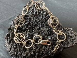 Gouden schakelarmband met monogrammen familiportret