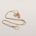 Gouden ketting of armband met vogel en amulet