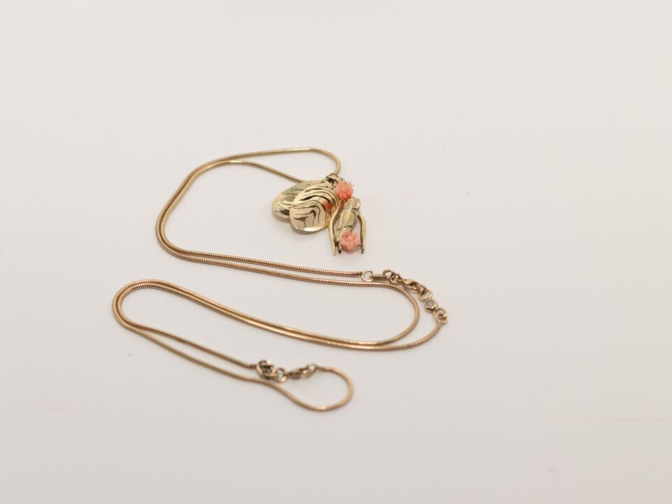 Gouden ketting of armband met vogel en amulet